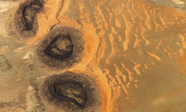 Trio of 'black mesas' leftover from Paleozoic era spawn rare sand dunes in the Sahara — Earth from space