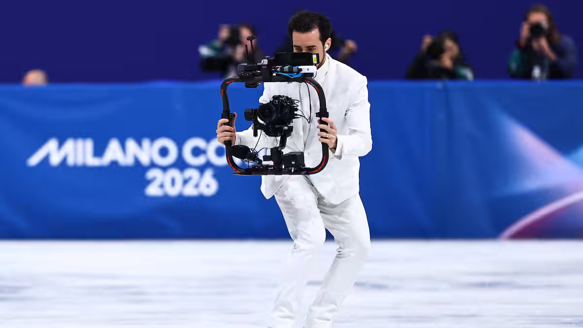 Il patine à reculons dans un complet blanc: ce caméraman vole la vedette aux Jeux olympiques d’hiver