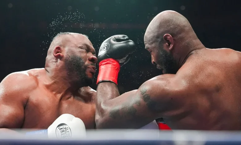 Boxer Jarrell Miller has hairpiece knocked upward by a punch, then throws it into the crowd