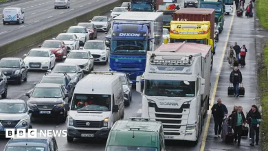 Irish fuel protests: People walk with luggage past heavy traffic on Dublin's M50