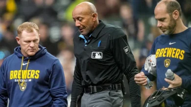 MLB umpire C.B. Bucknor leaves the game after taking foul ball to the face