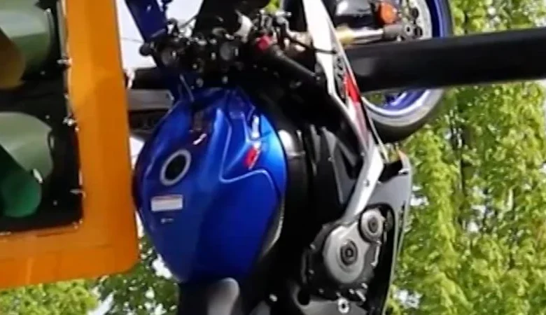 Motorcycle dangles from traffic light pole after crash