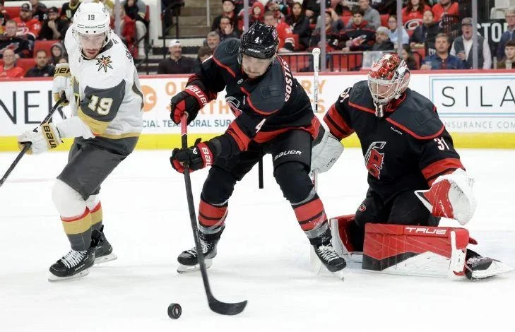 Carolina defenseman Shayne Gostisbehere (4) and goaltender Frederik Andersen (31) defend Vegas right wing Reilly Smith (19) during the first period on Oct. 28, 2025, in Raleigh, N.C.